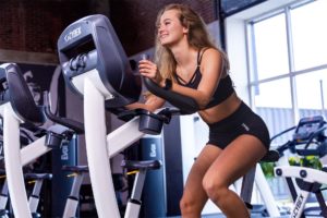 Sportieve vrouw is aan het fietsen in een sportschool