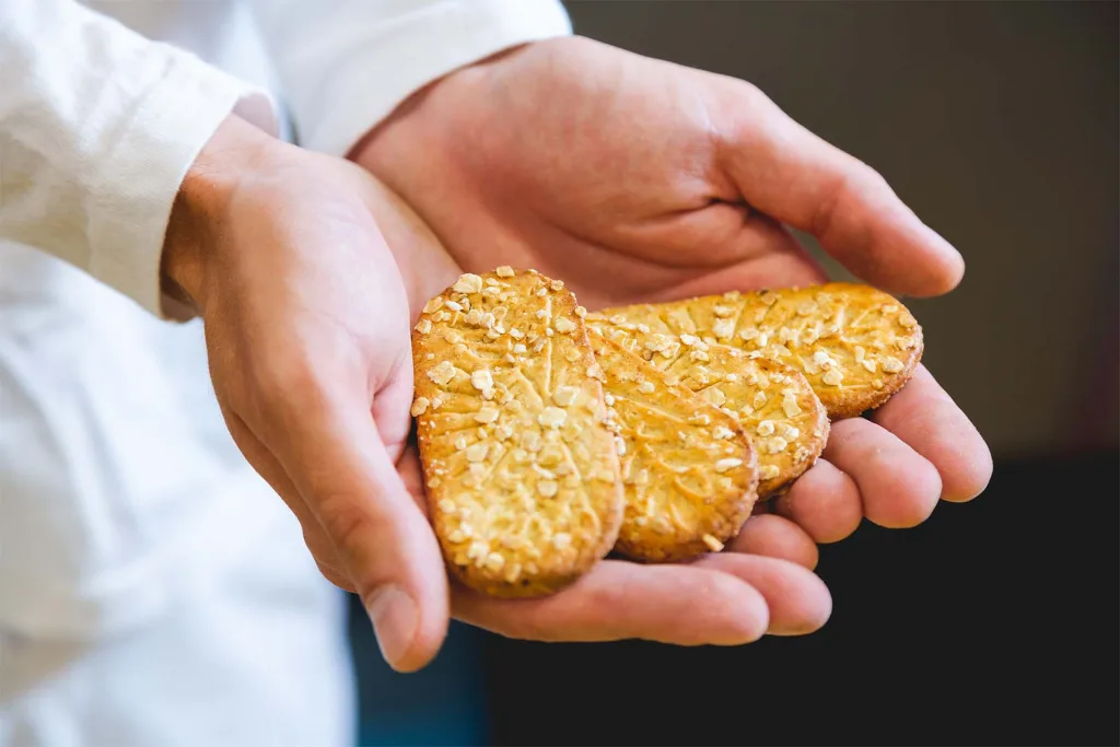 Koekjes in de handen van een medewerker van Hellema